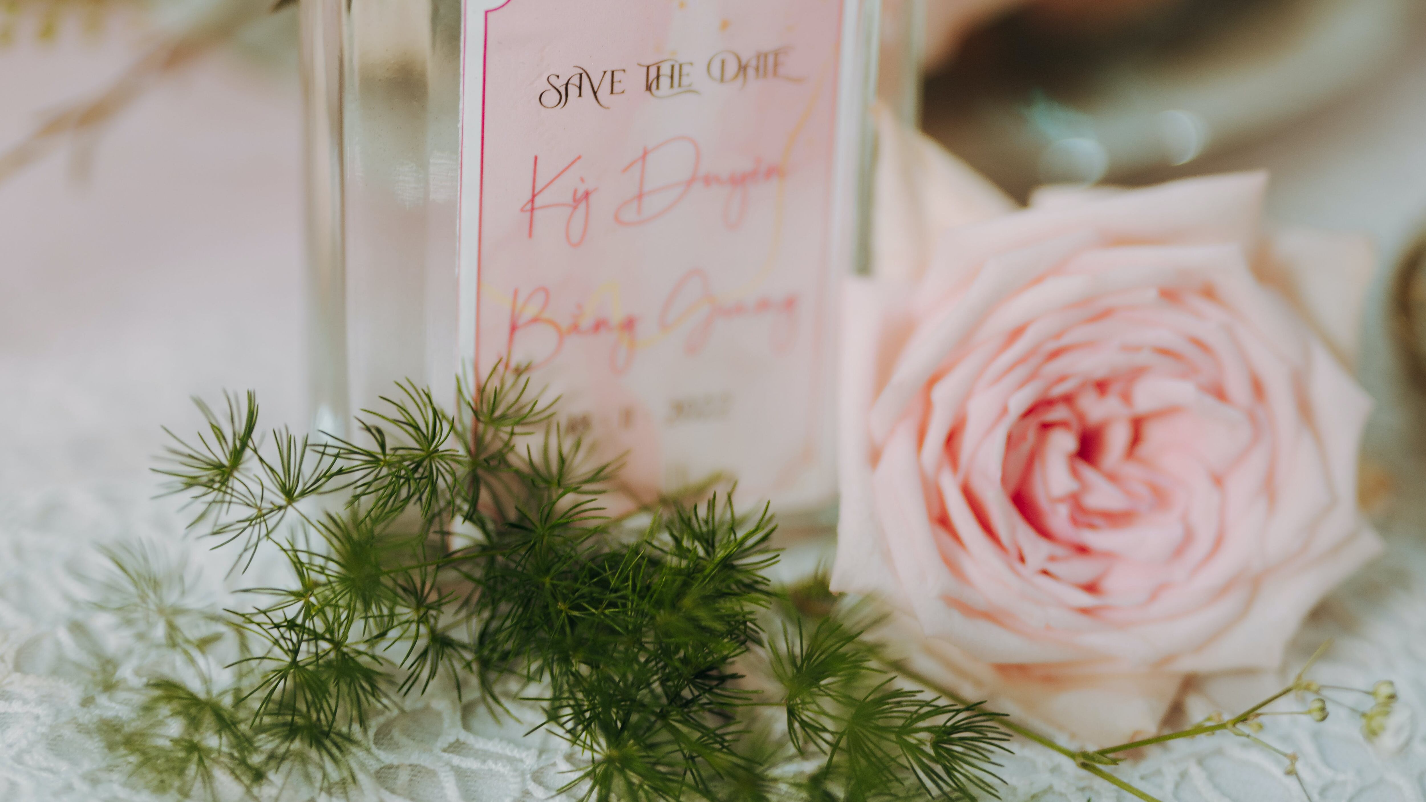 Frasco de perfume com rosa ao lado