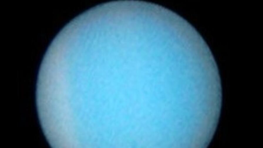 Esta visão rara e extraordinária mostra os anéis fracos do planeta de lado.