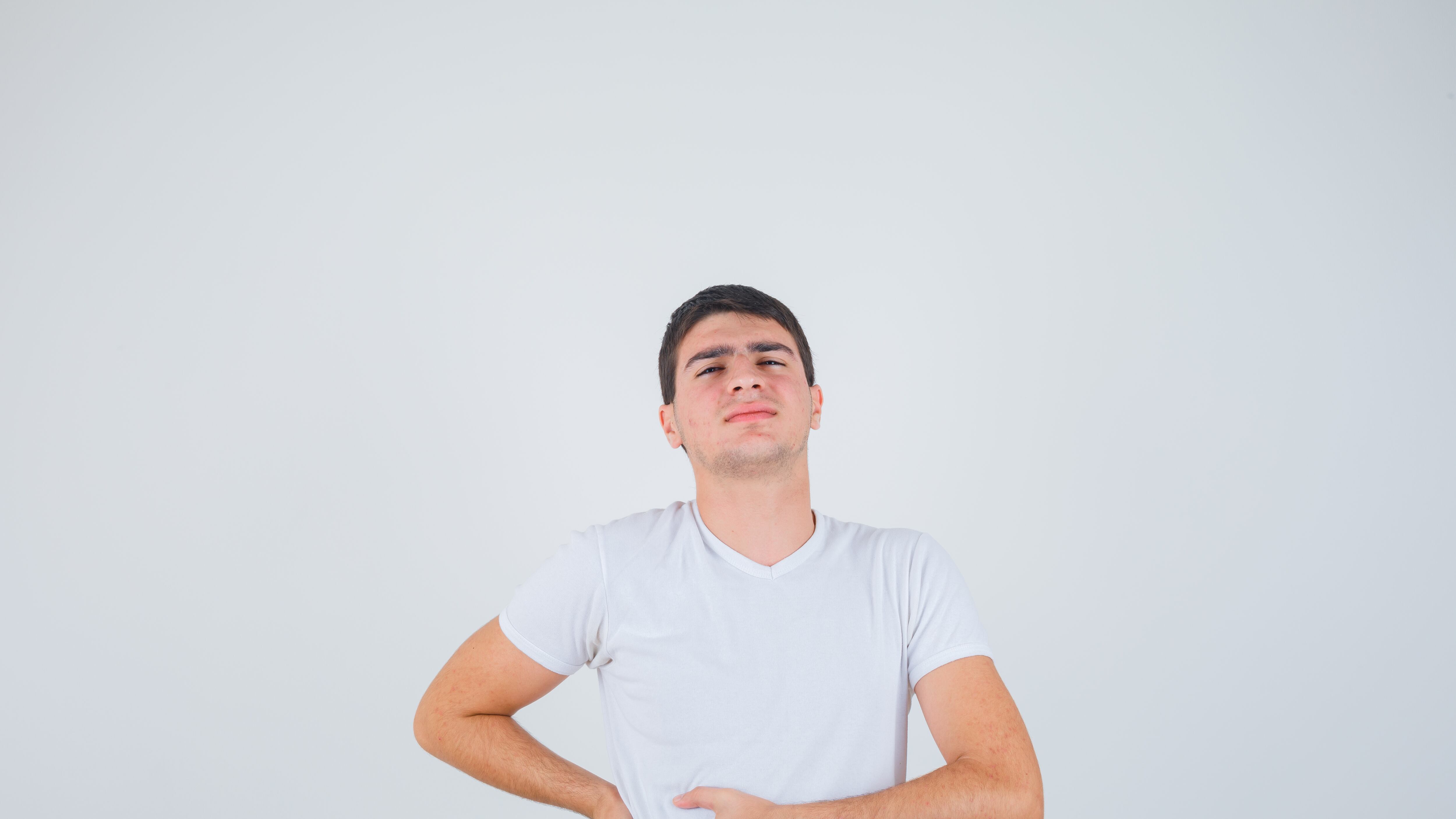 Homem branco com camisa branco colocando a mão na barriga