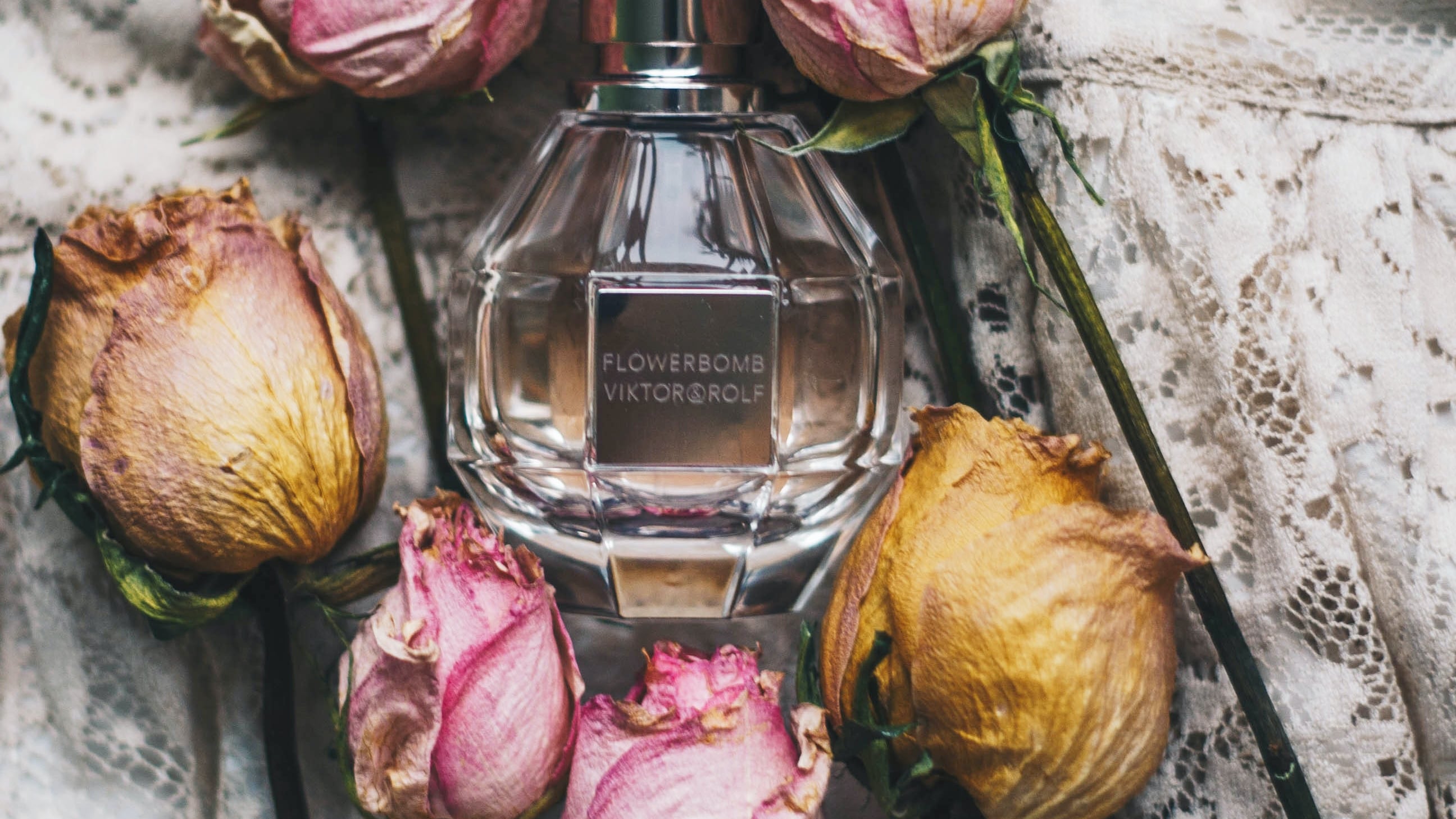 Frasco de perfume com rosas do lado