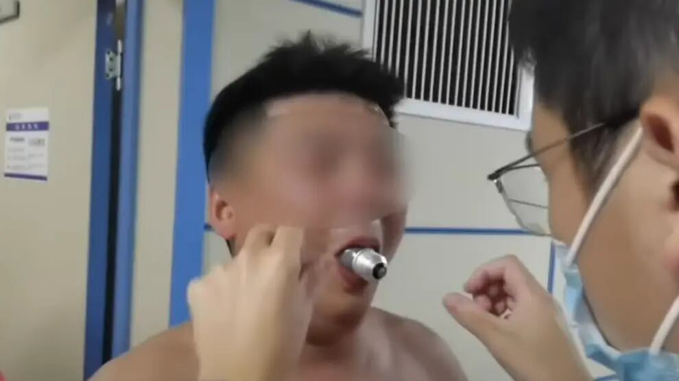 Homem com lampada presa na boca