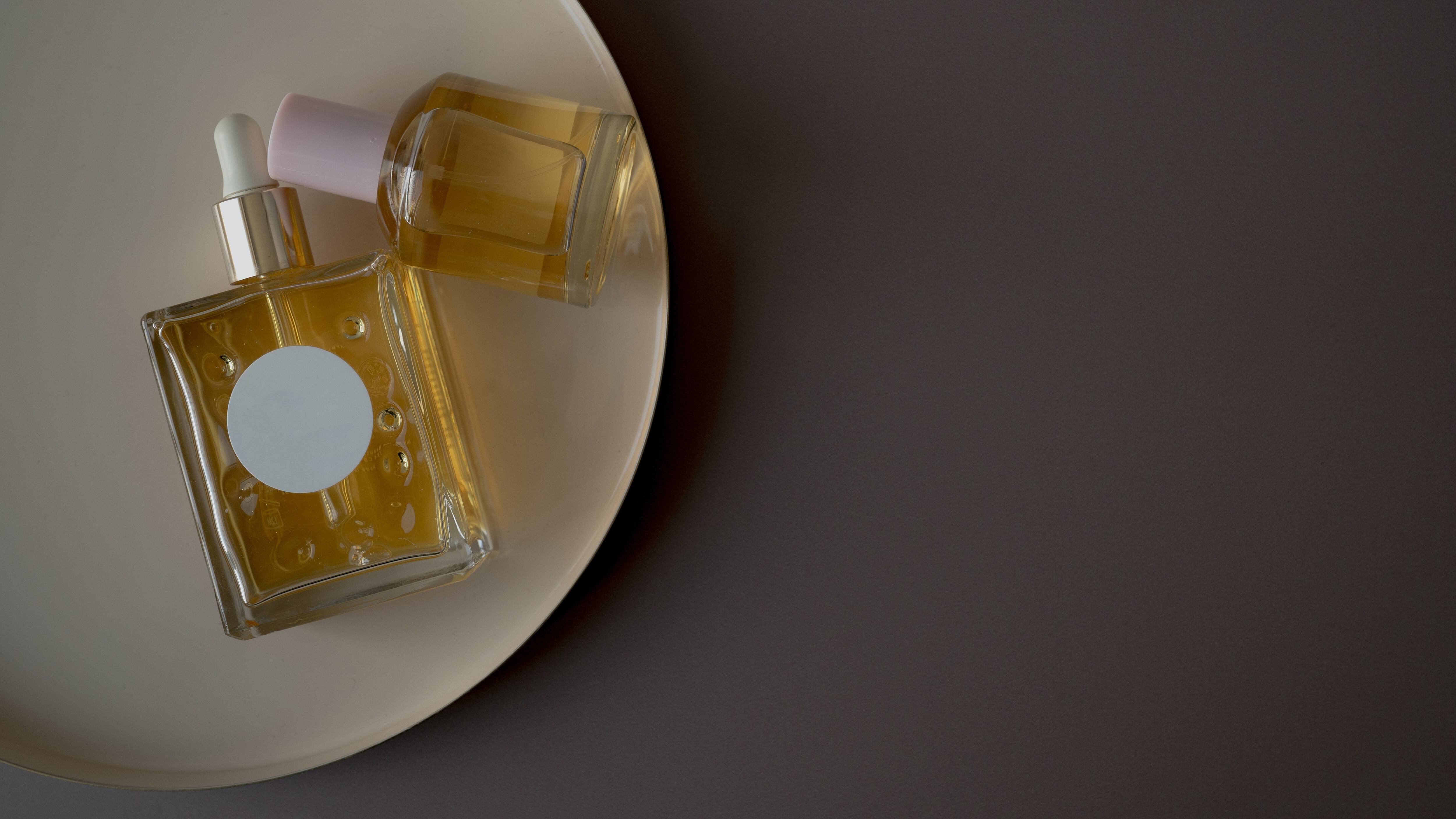 Dois frascos de perfumes com líquido dourado