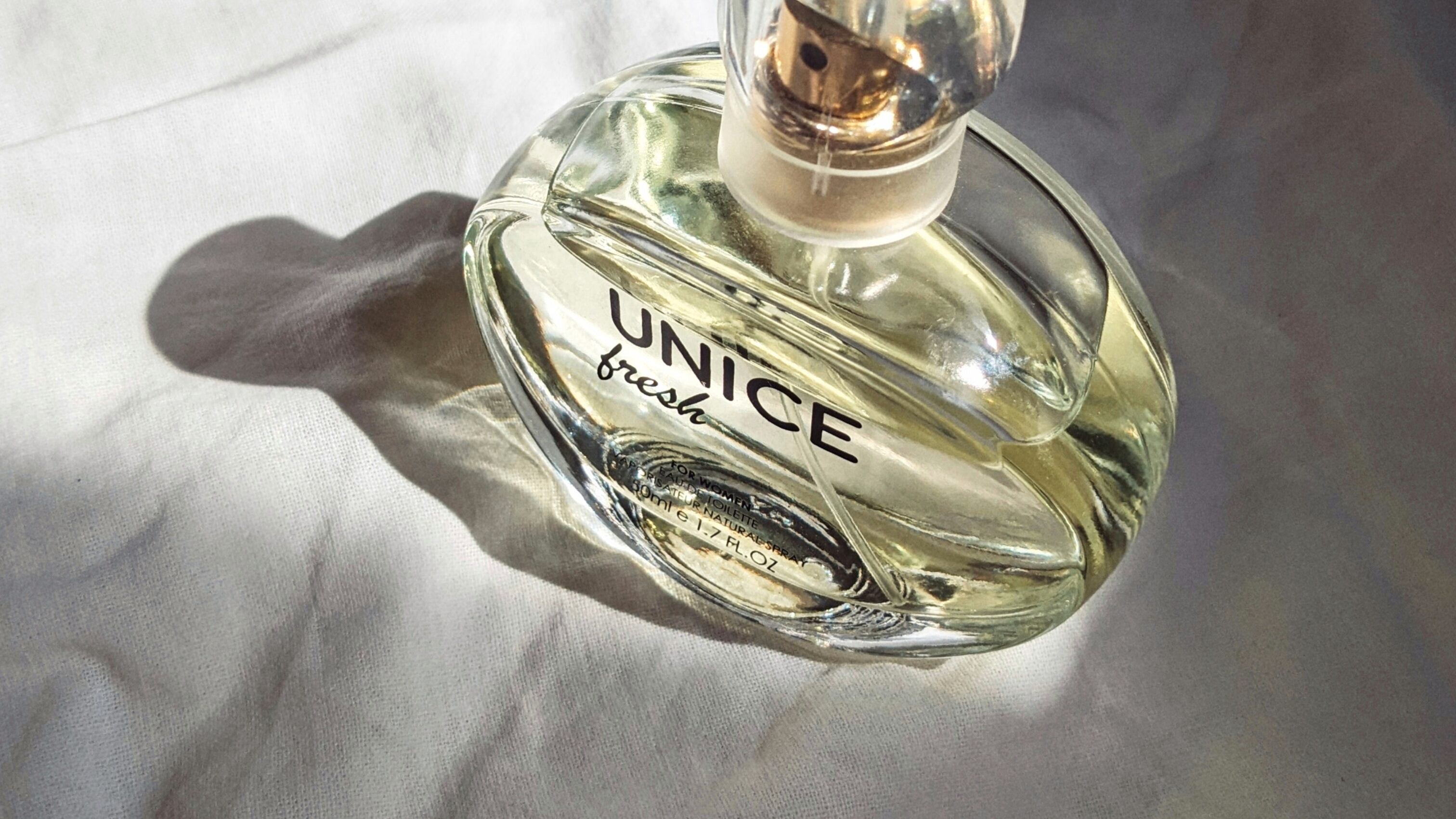 Frasco de perfume Unice Fresh recebendo feixe de luz do sol