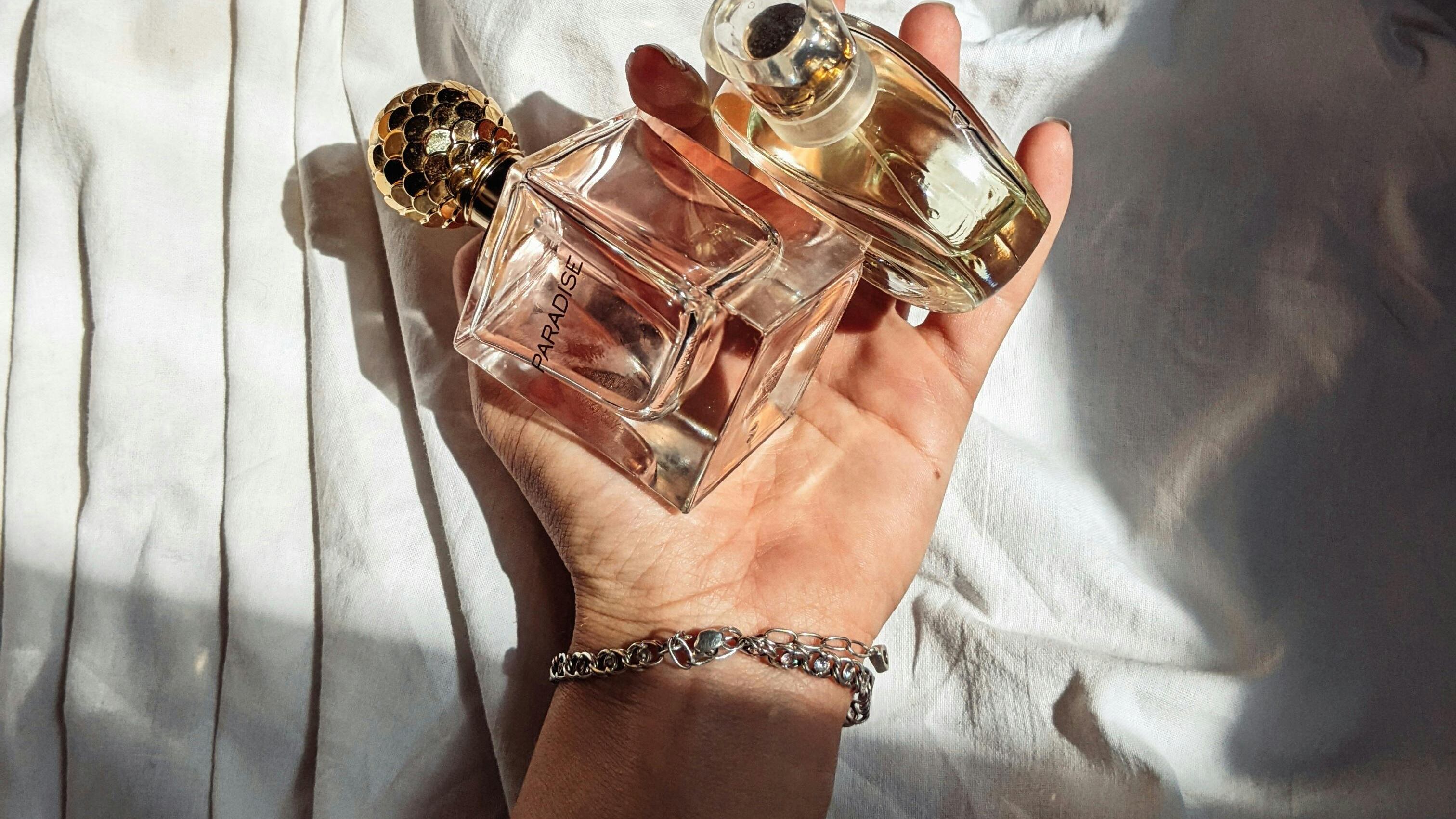 Frasco de perfumes nas mãos