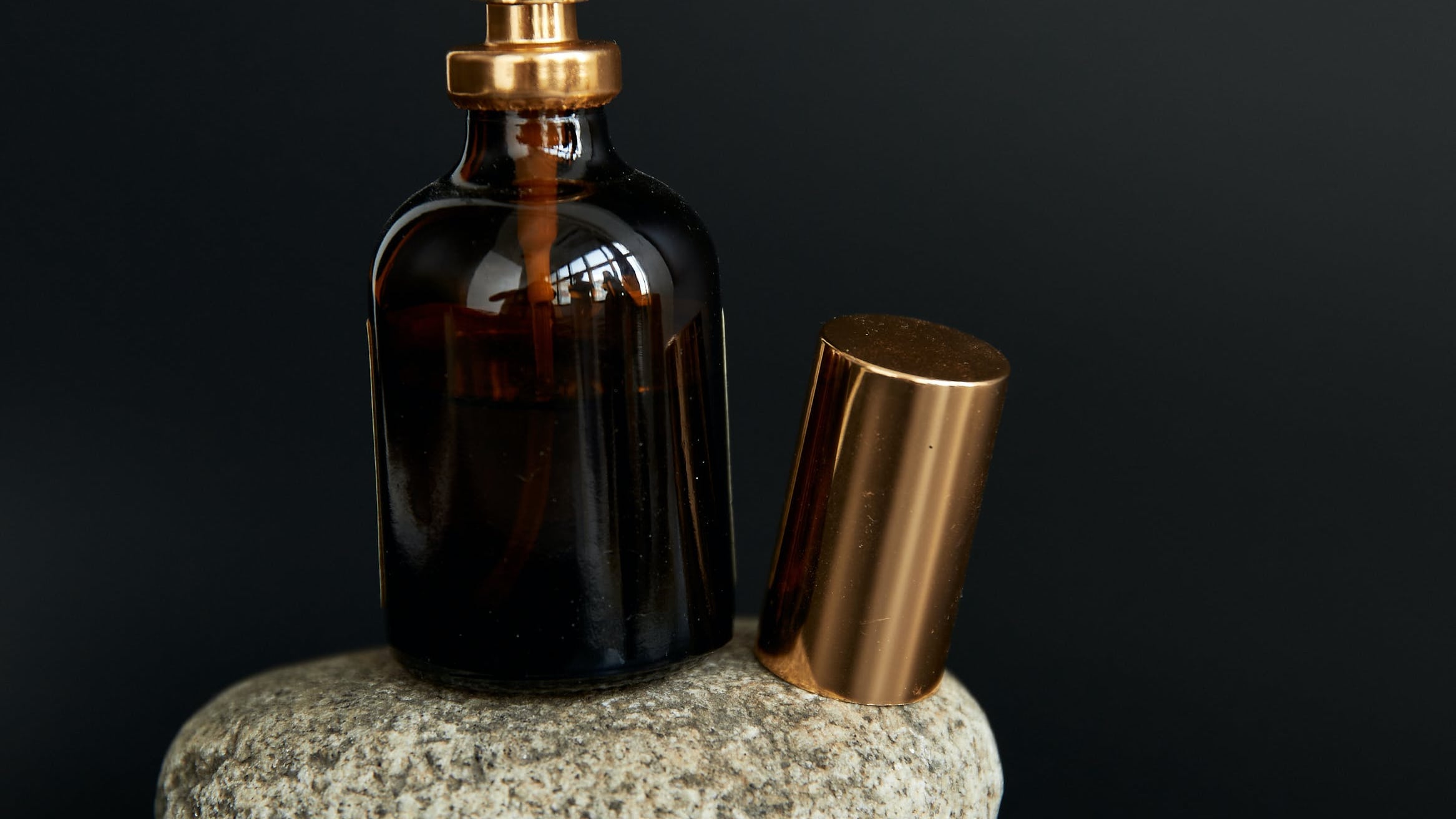 Frasco de perfume em cima de duas pedras