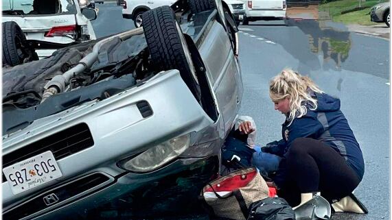 Bombeira Megan Warfield, grávida, atendendo uma vítima de acidente