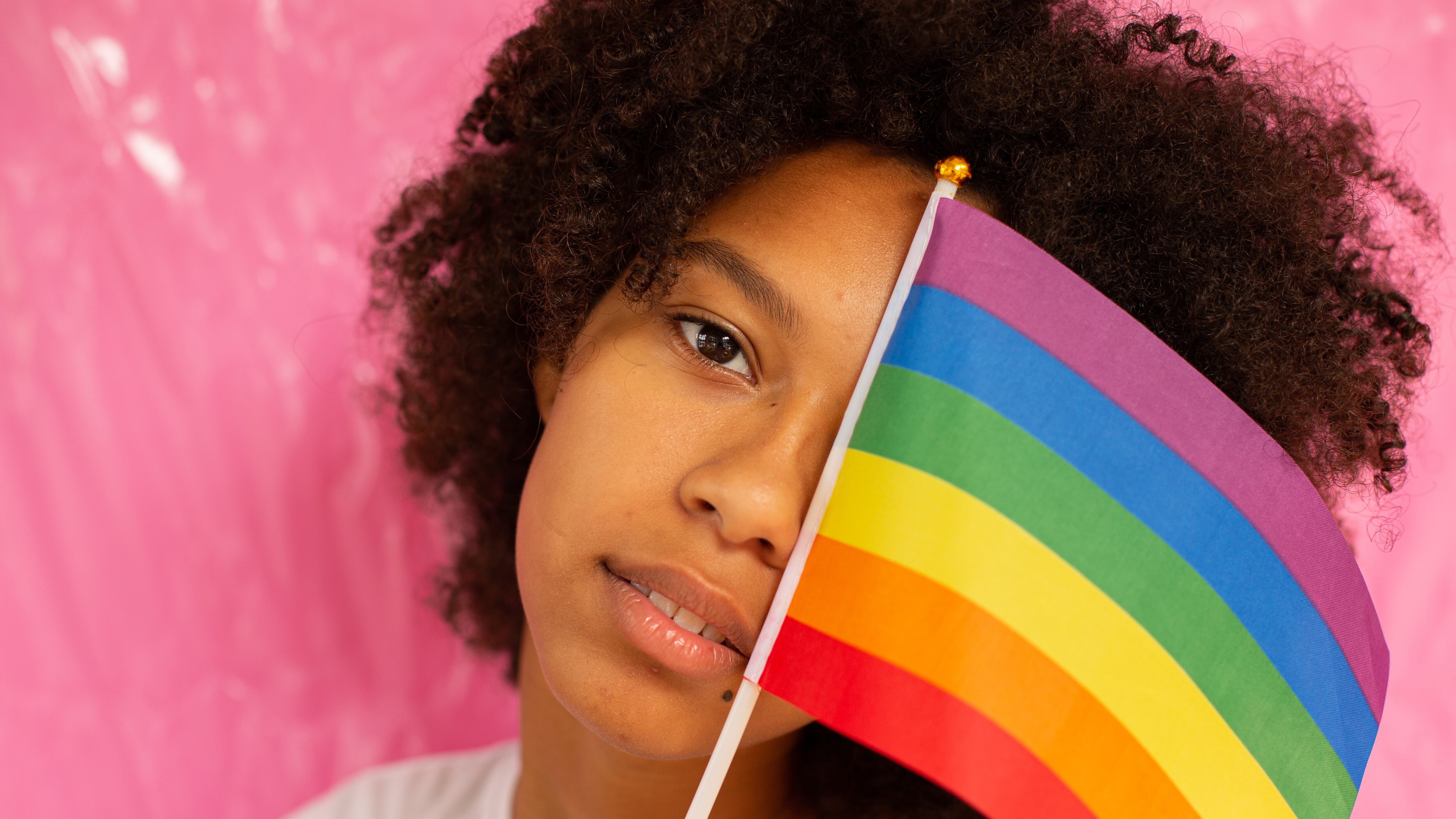 Mulher preta segurando bandeira LGBTQIAP+
