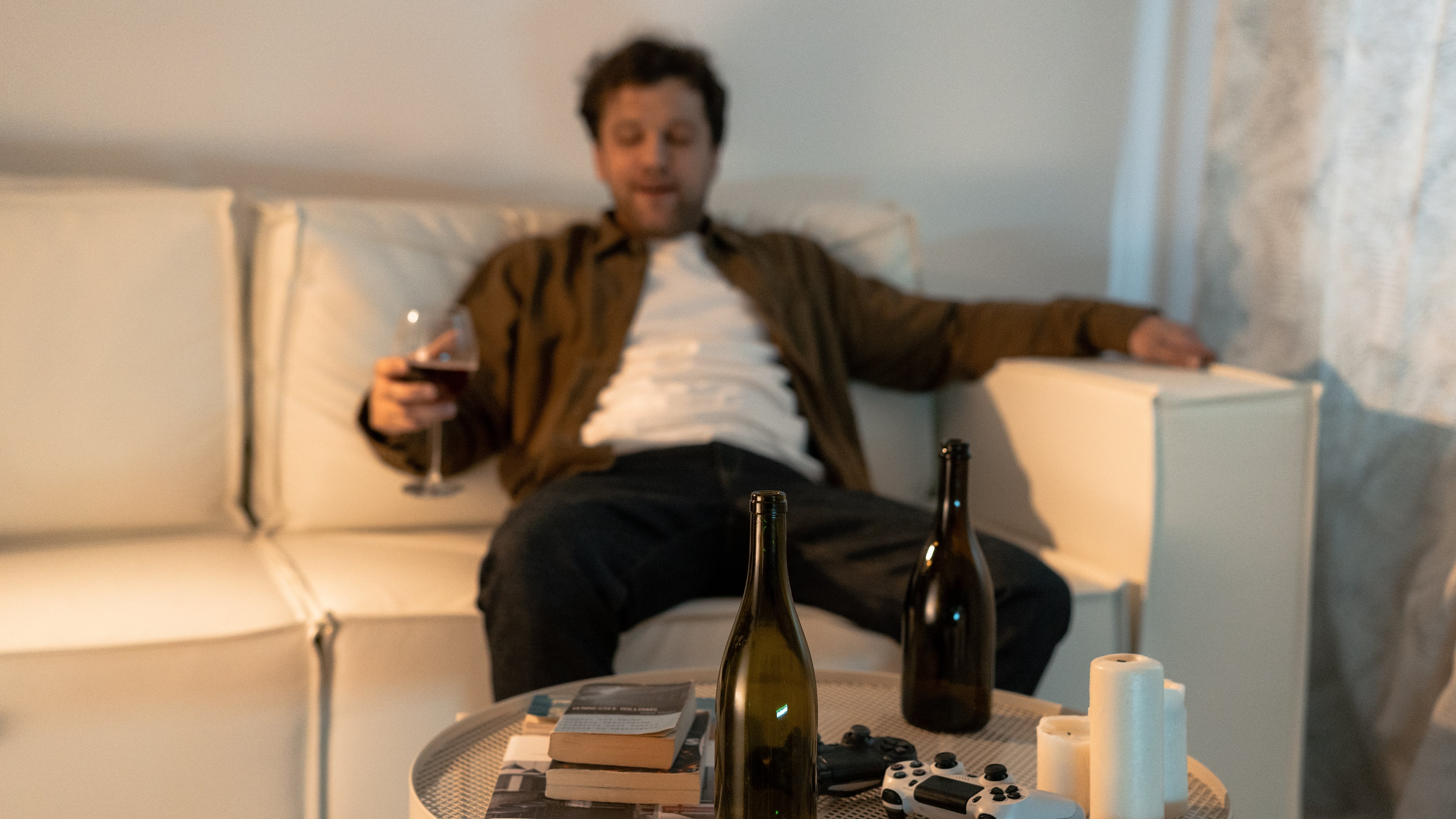 Homem bebendo vinho sentado no sofá