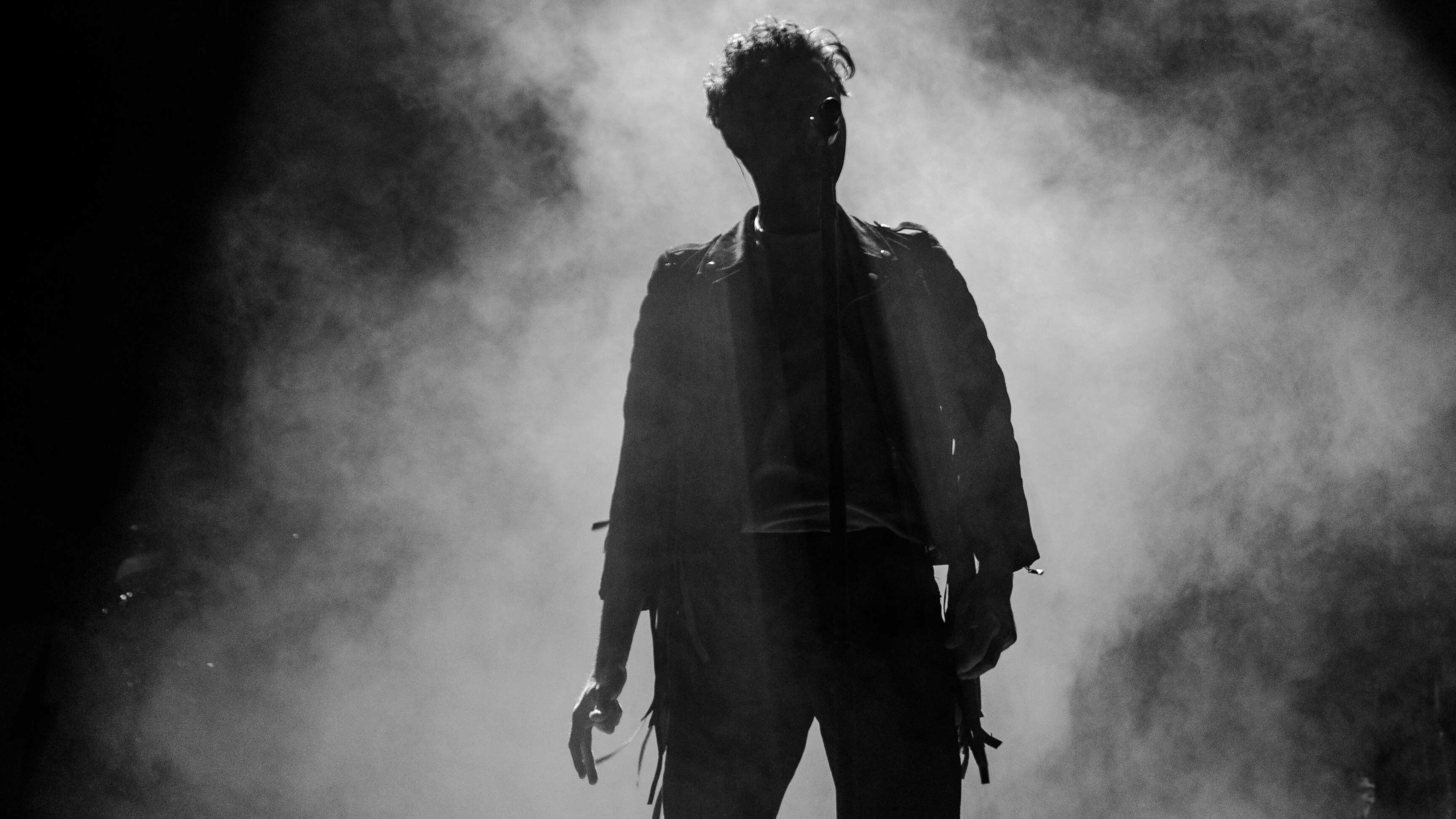 Silhueta de homem atrás de fumaça preta