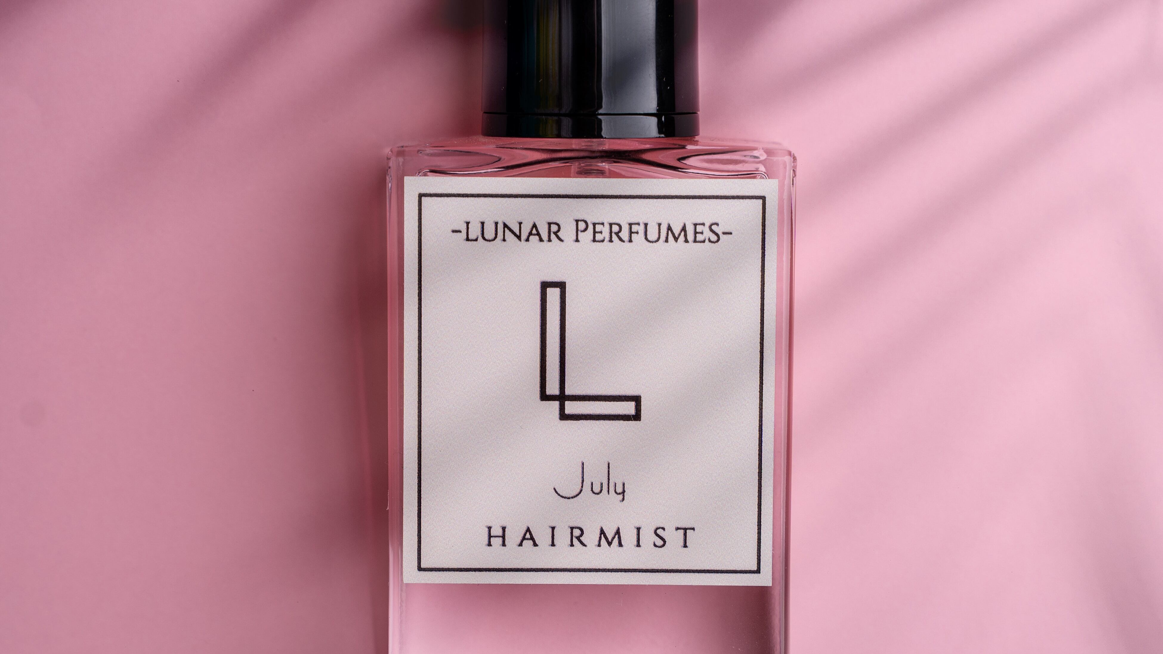 Frasco de perfume com fundo rosa