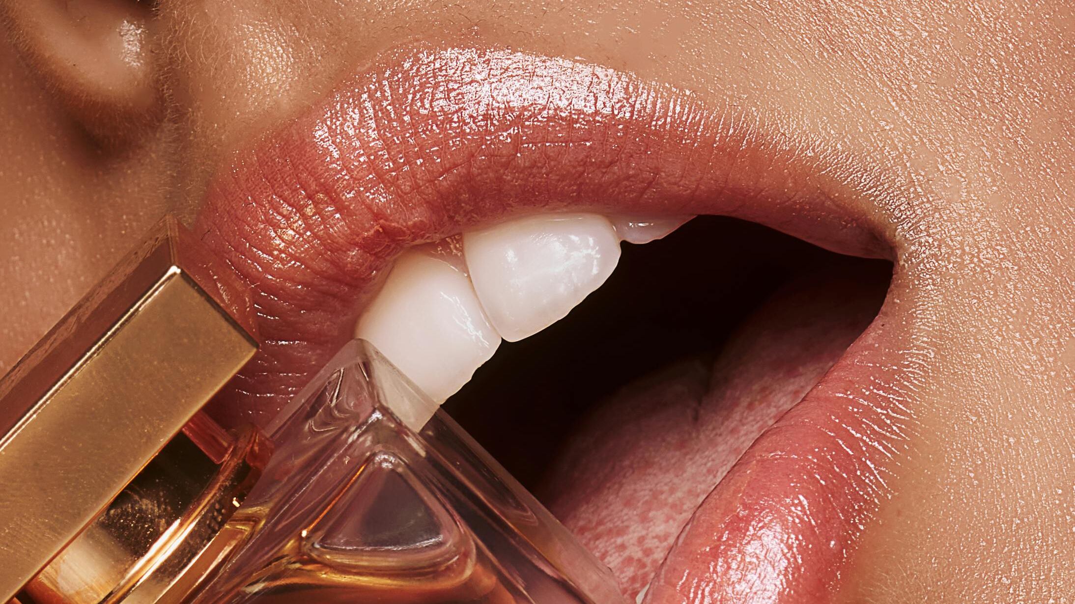 Boca feminina ao lado de perfume
