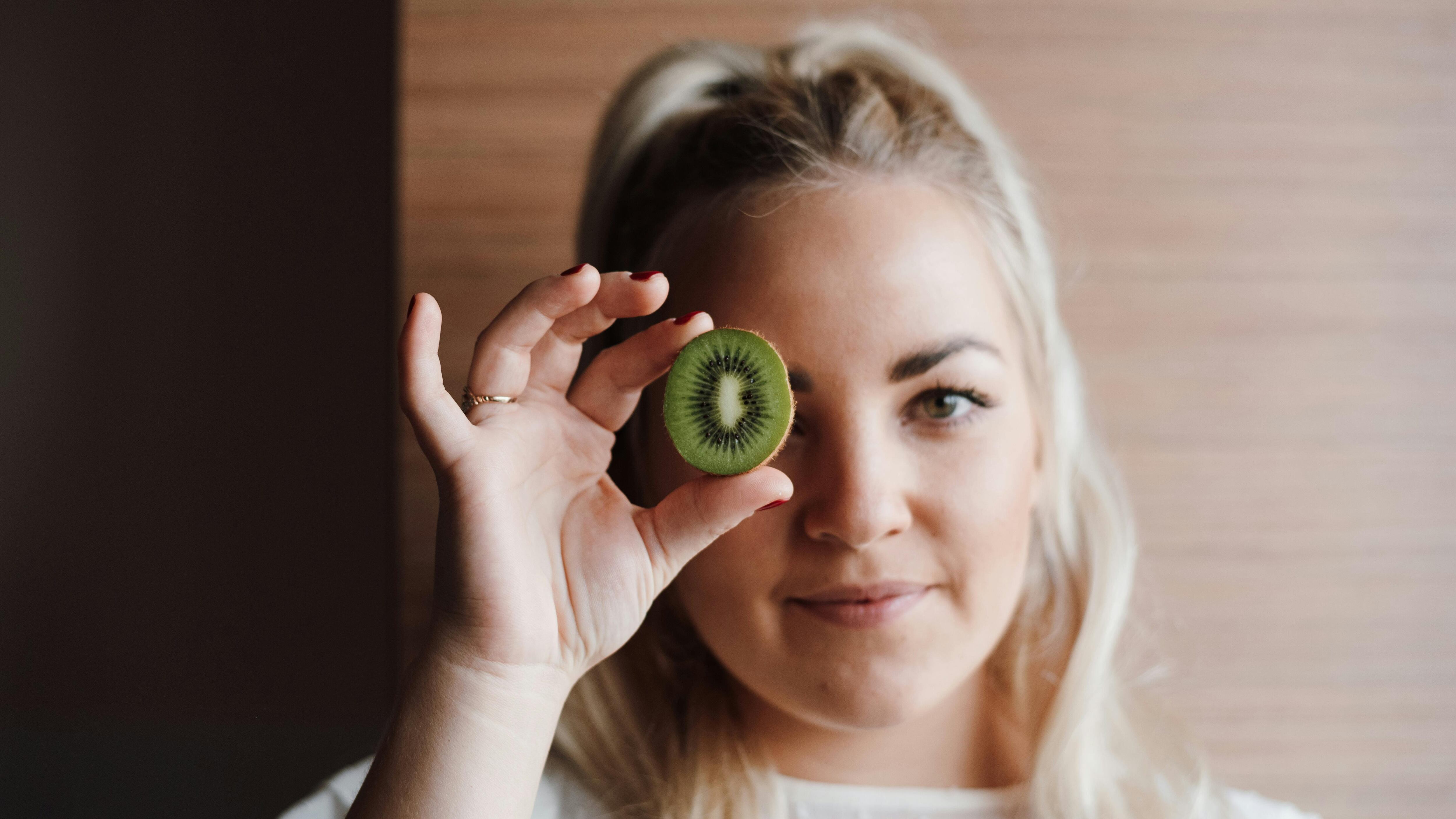 Mulher segurando kiwi