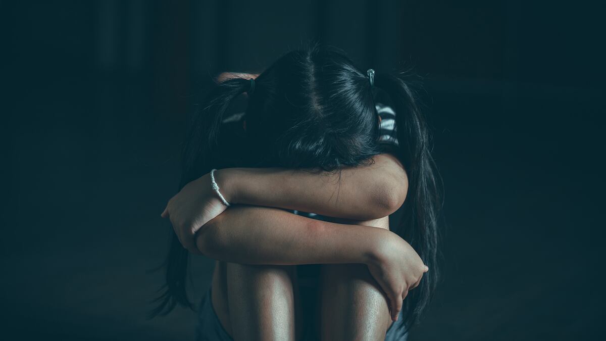 #EmCasaSemViolência: campanha alerta sobre abusos contra crianças e adolescentes; menina de cabeça baixa apoiada sobre joelhos