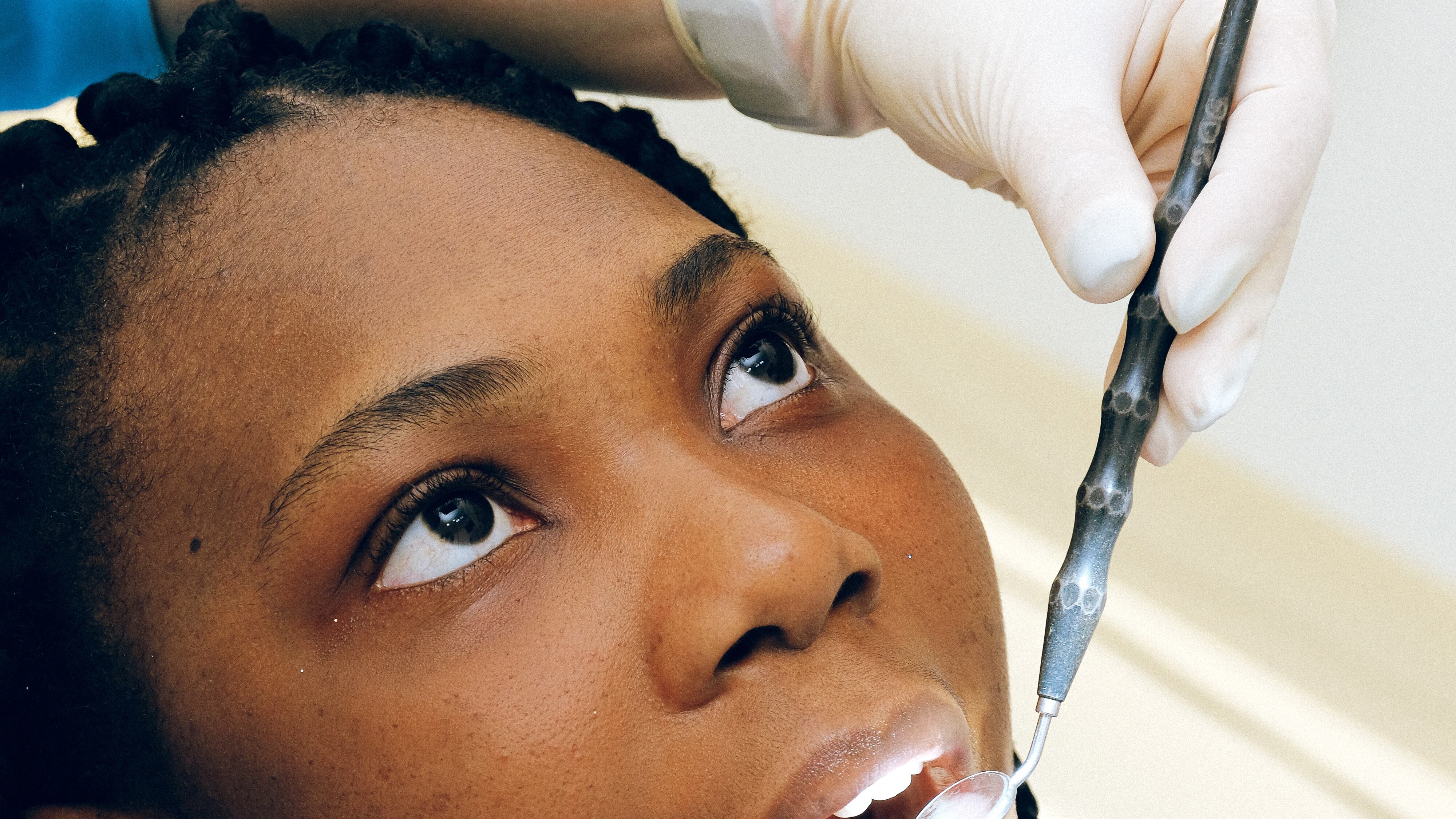 Mulher negra sendo consultada por dentista