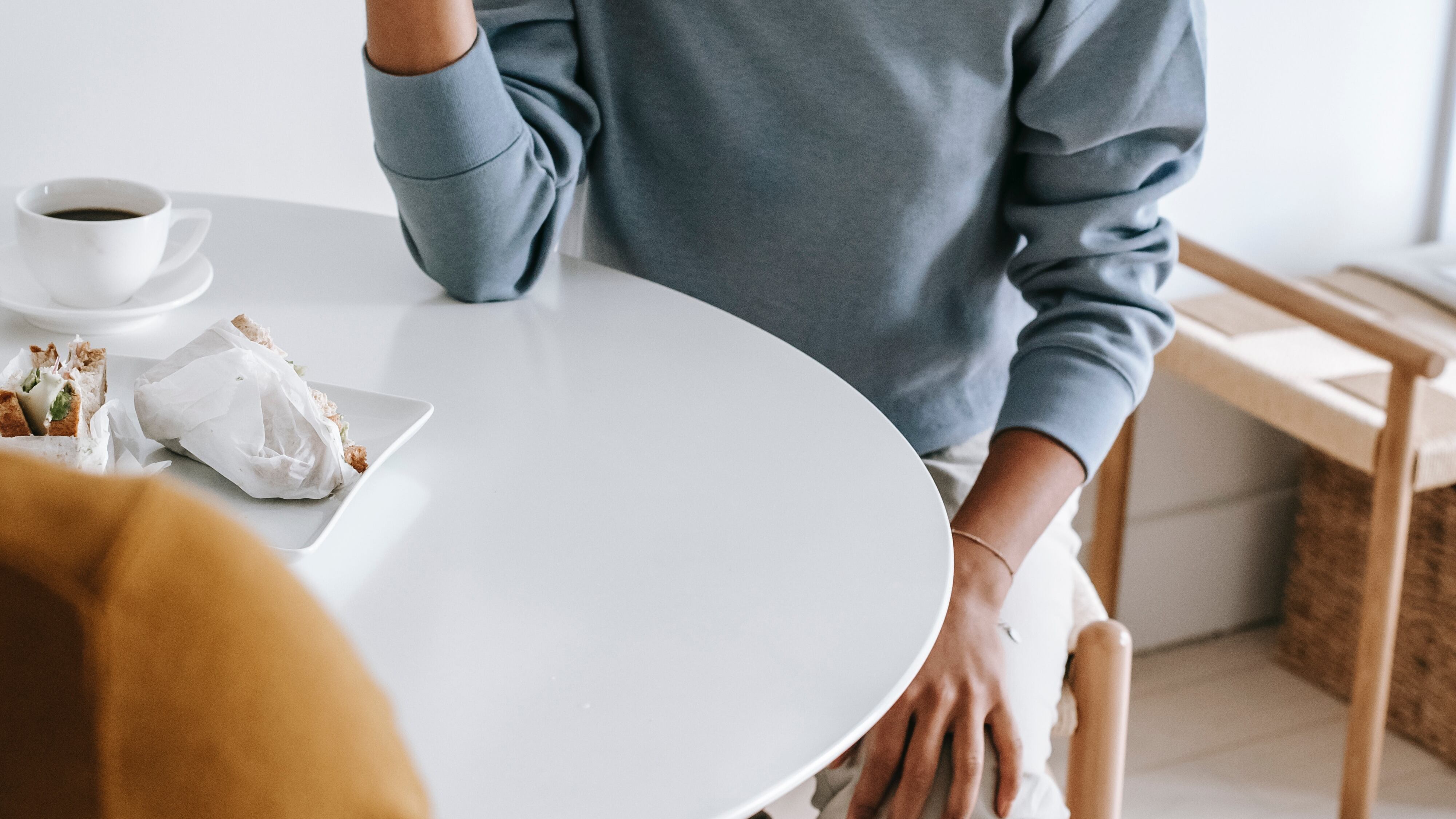 Mulher negra tomando café com a mão na cabeça