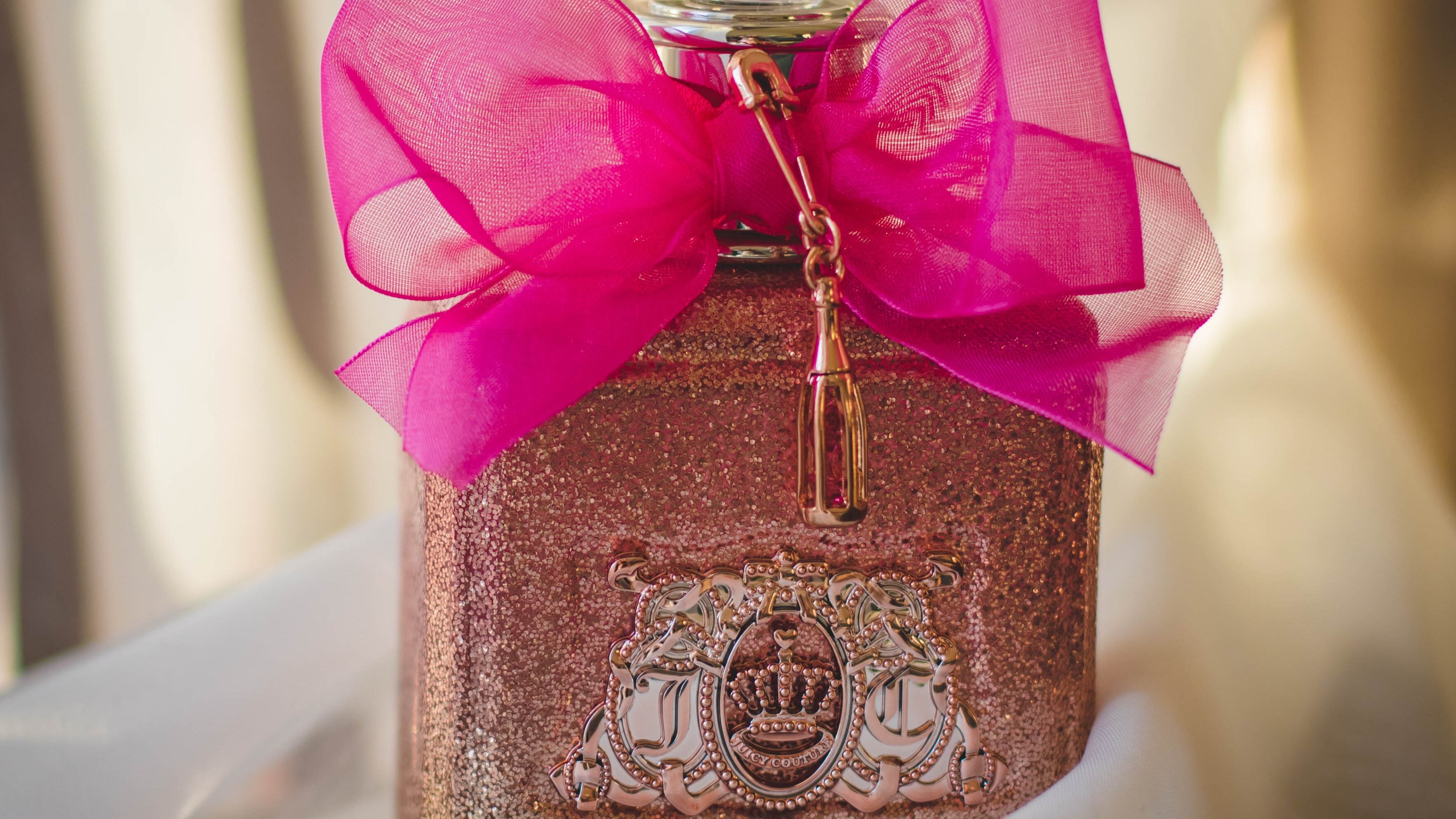 Frasco de perfume rosa com laço