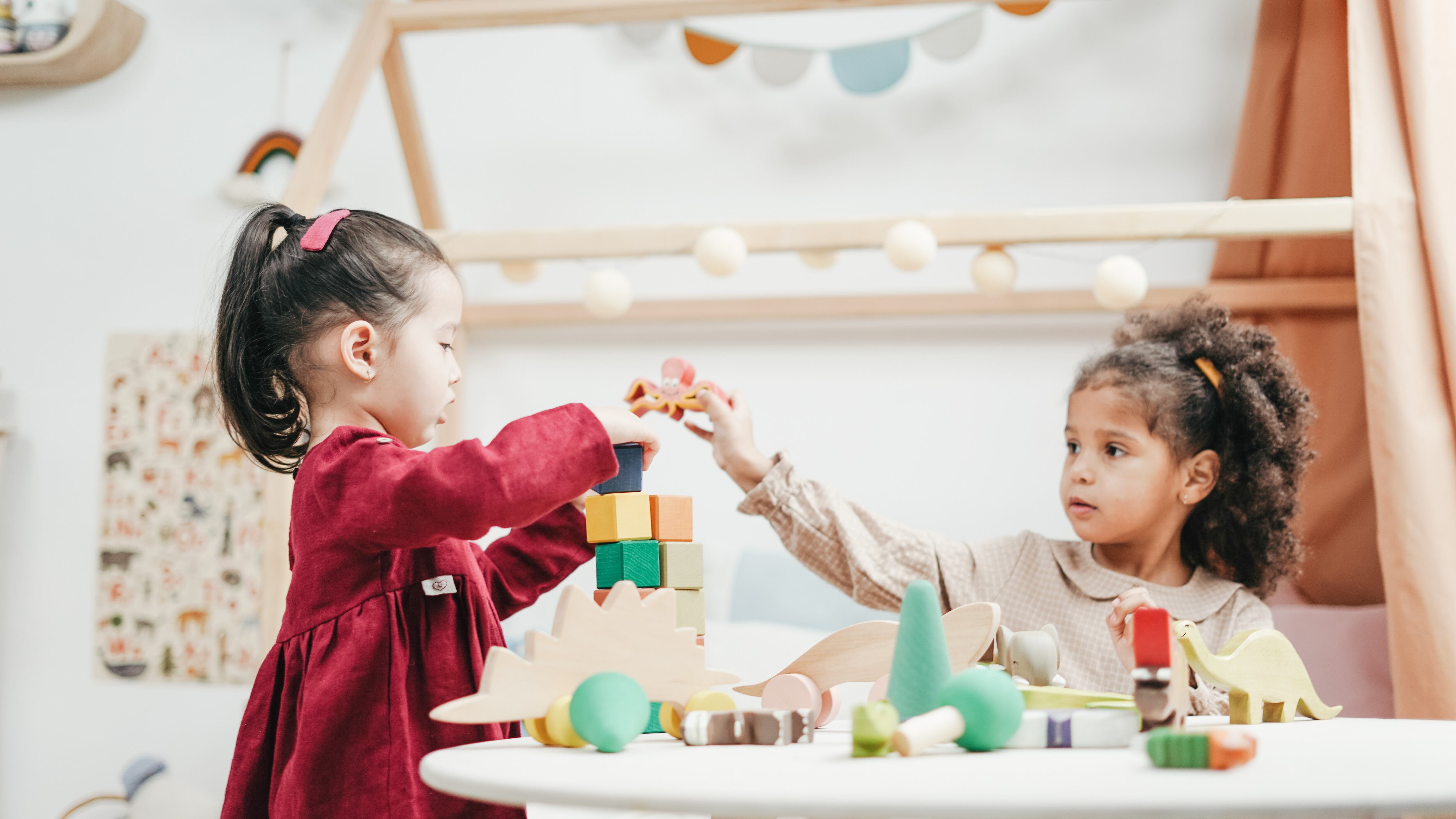 Crianças brincando com peças em cima da mesa
