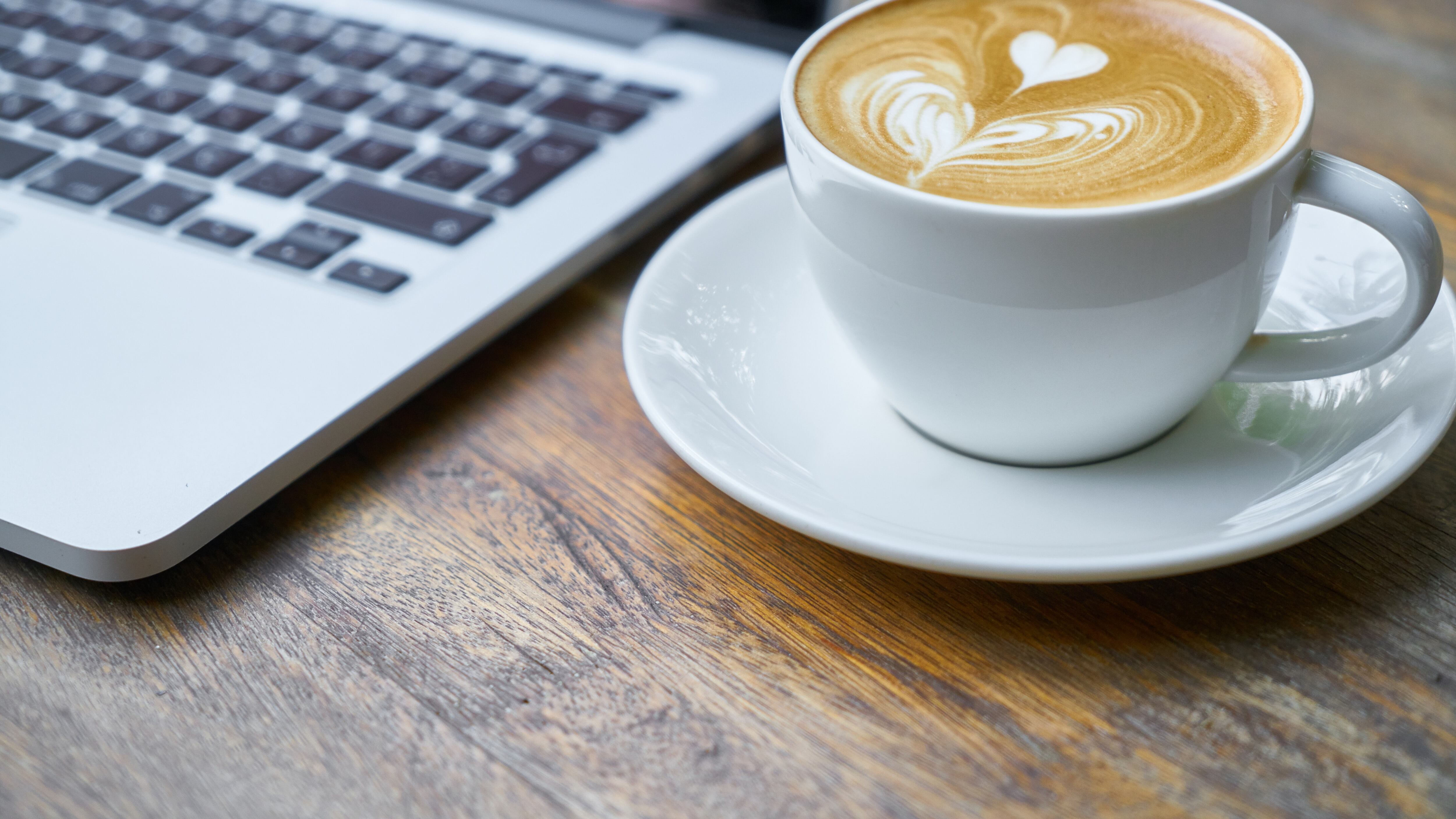 Xícara de café ao lado de notebook