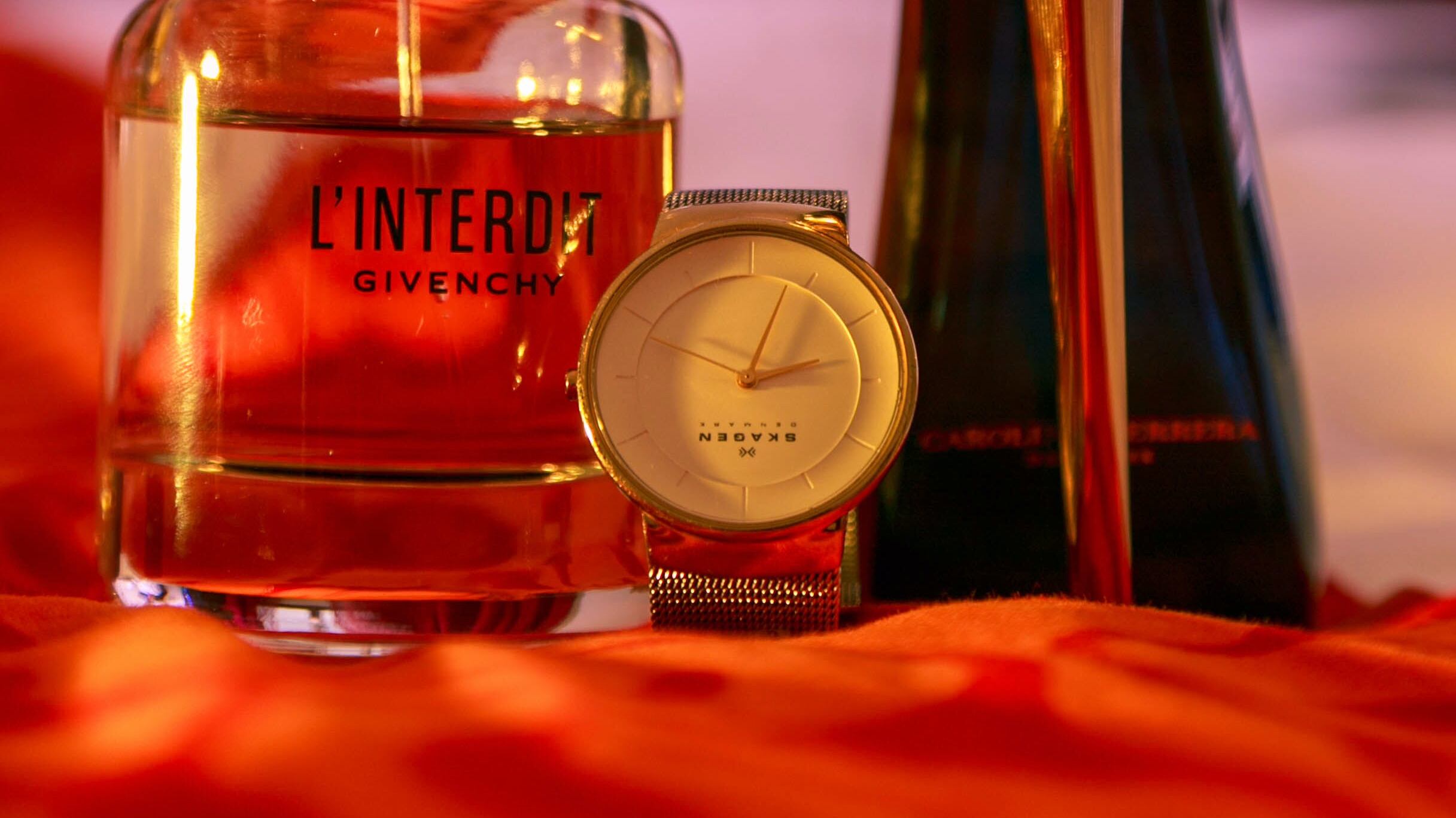 Frasco de perfume ao lado de relógio e salto alto