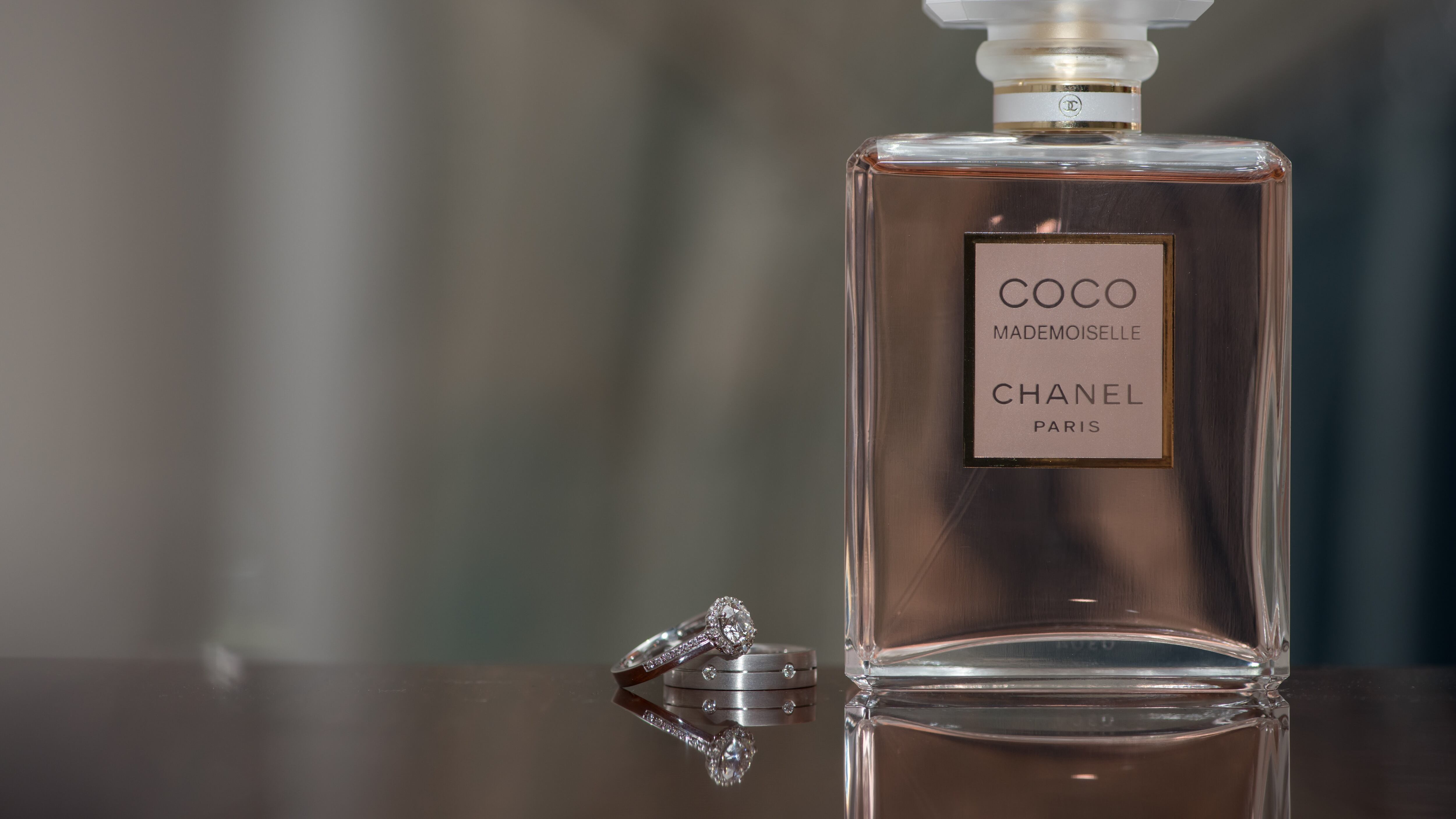 Frasco de perfume Coco Mademoiselle ao lado de anel feminino