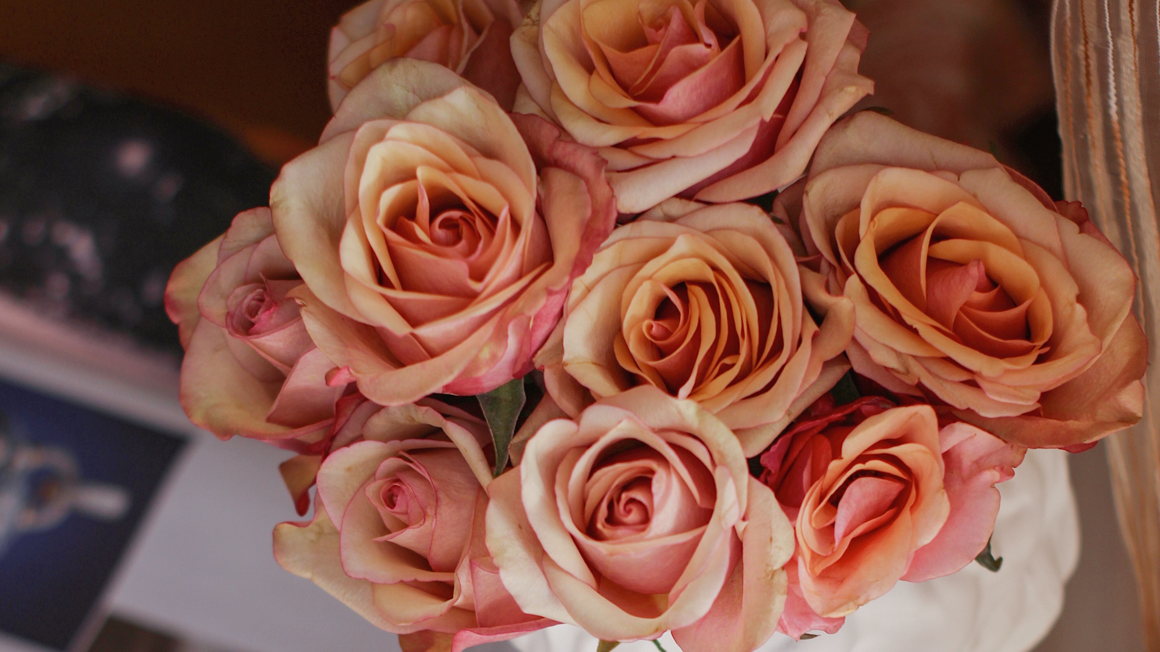 Frasco de perfume J'Adore ao lado de buquê de rosas