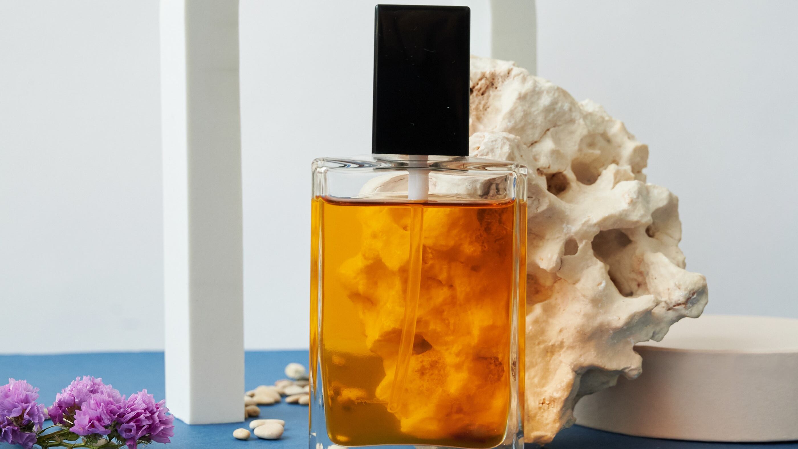 Frasco de perfume transparente com líquido laranja