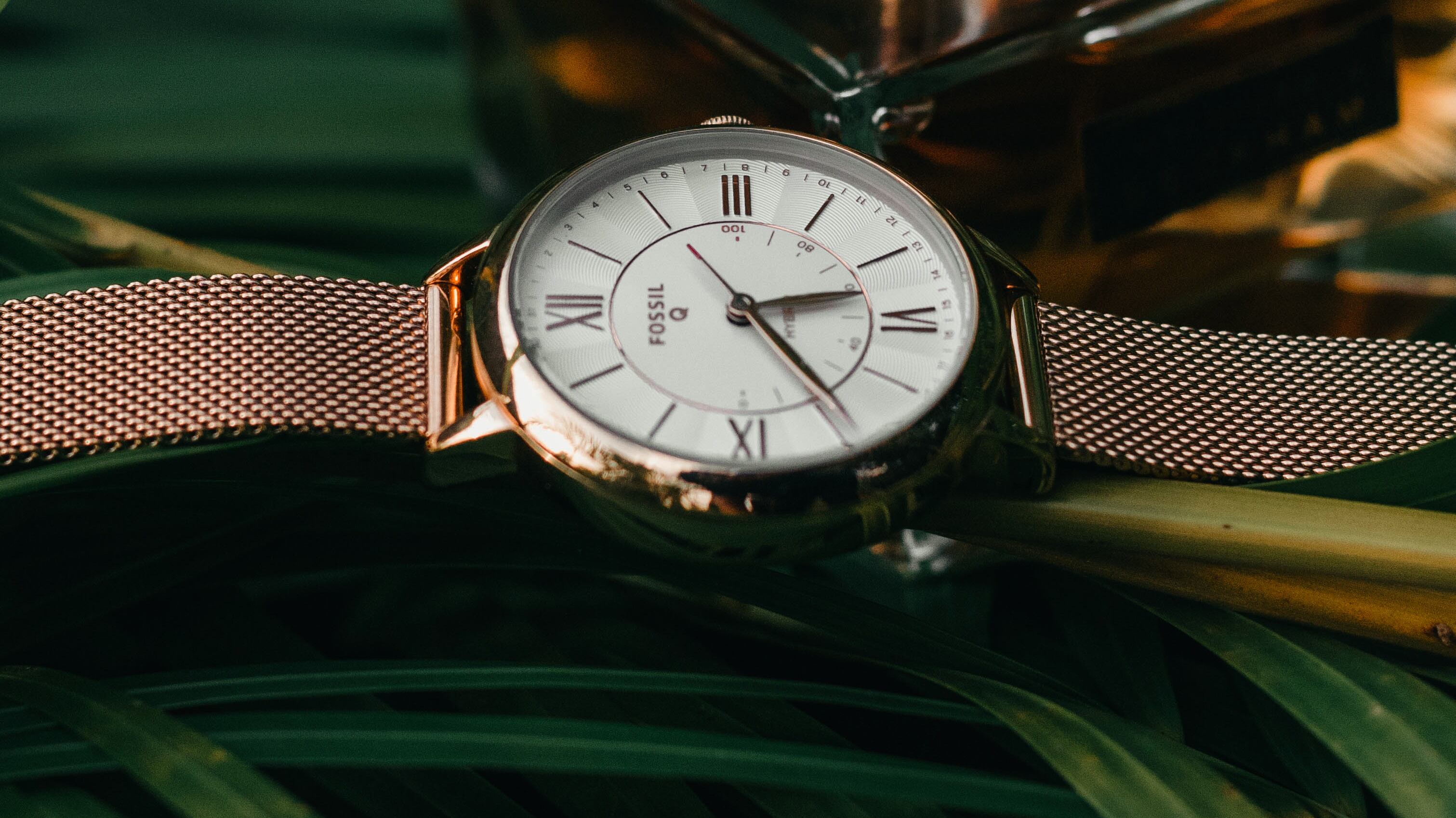 Perfume ao lado de relógio