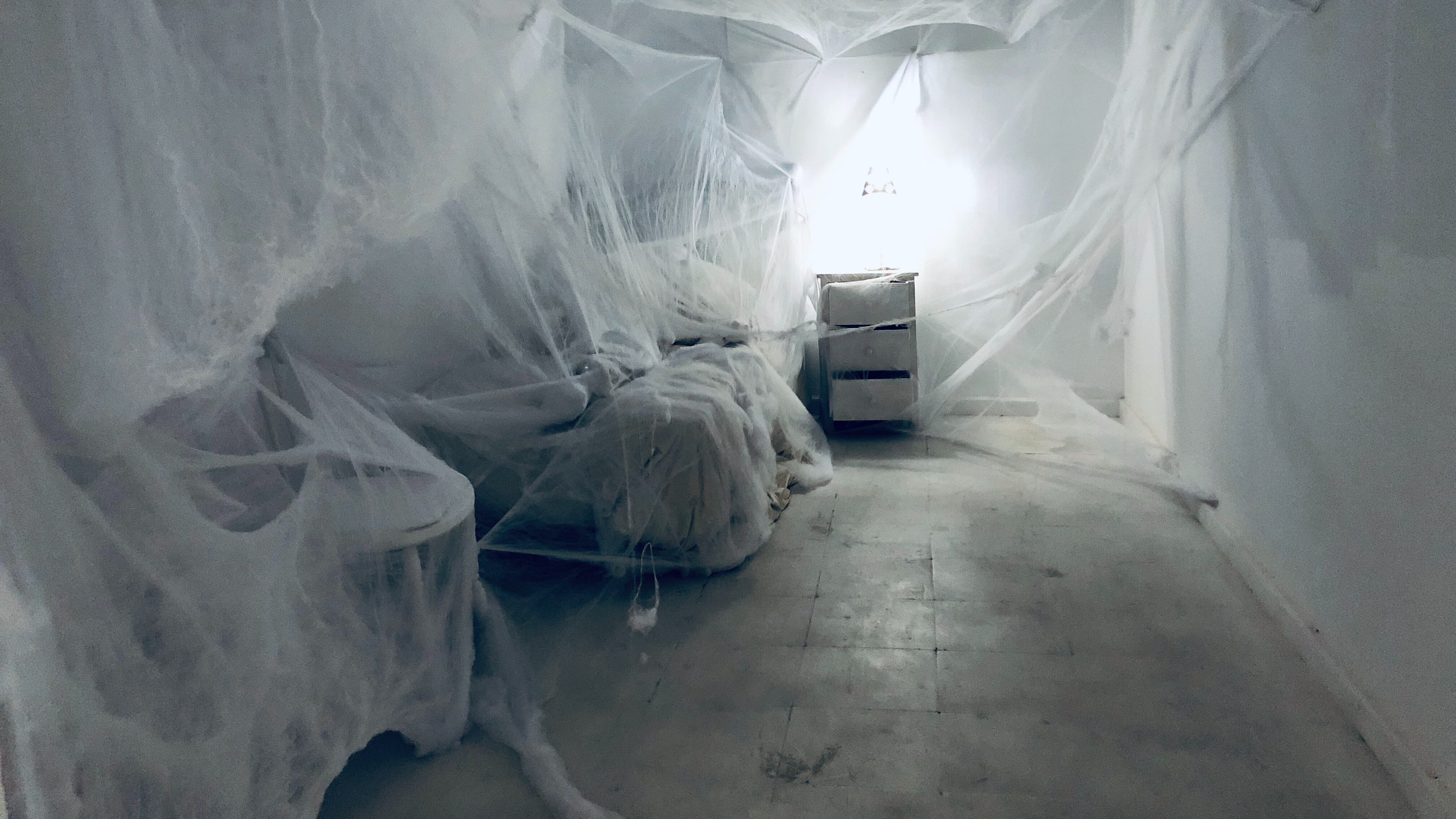 Quarto branco coberto de teia de aranha