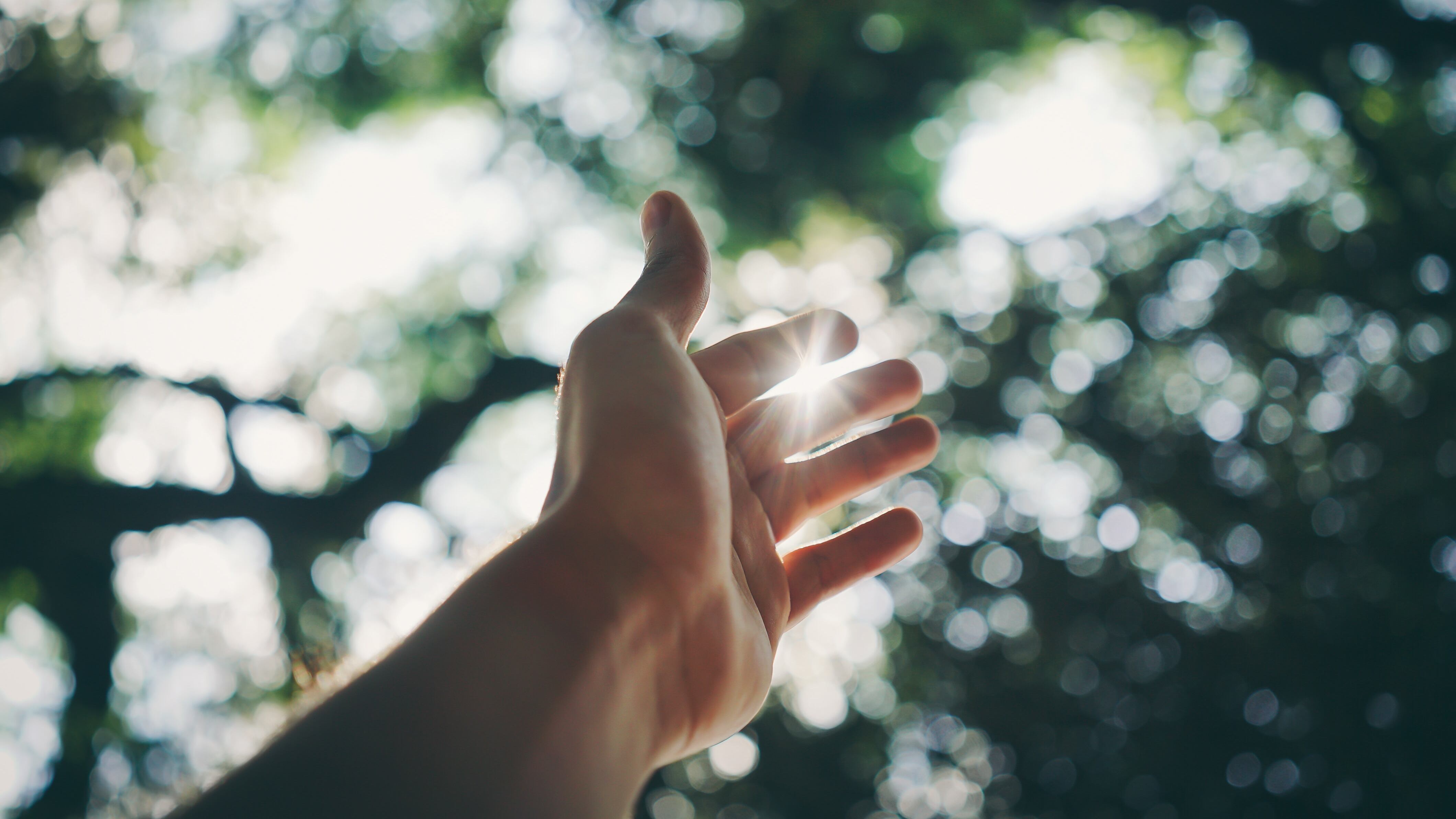 Silhueta de mão apontando para raio de sol