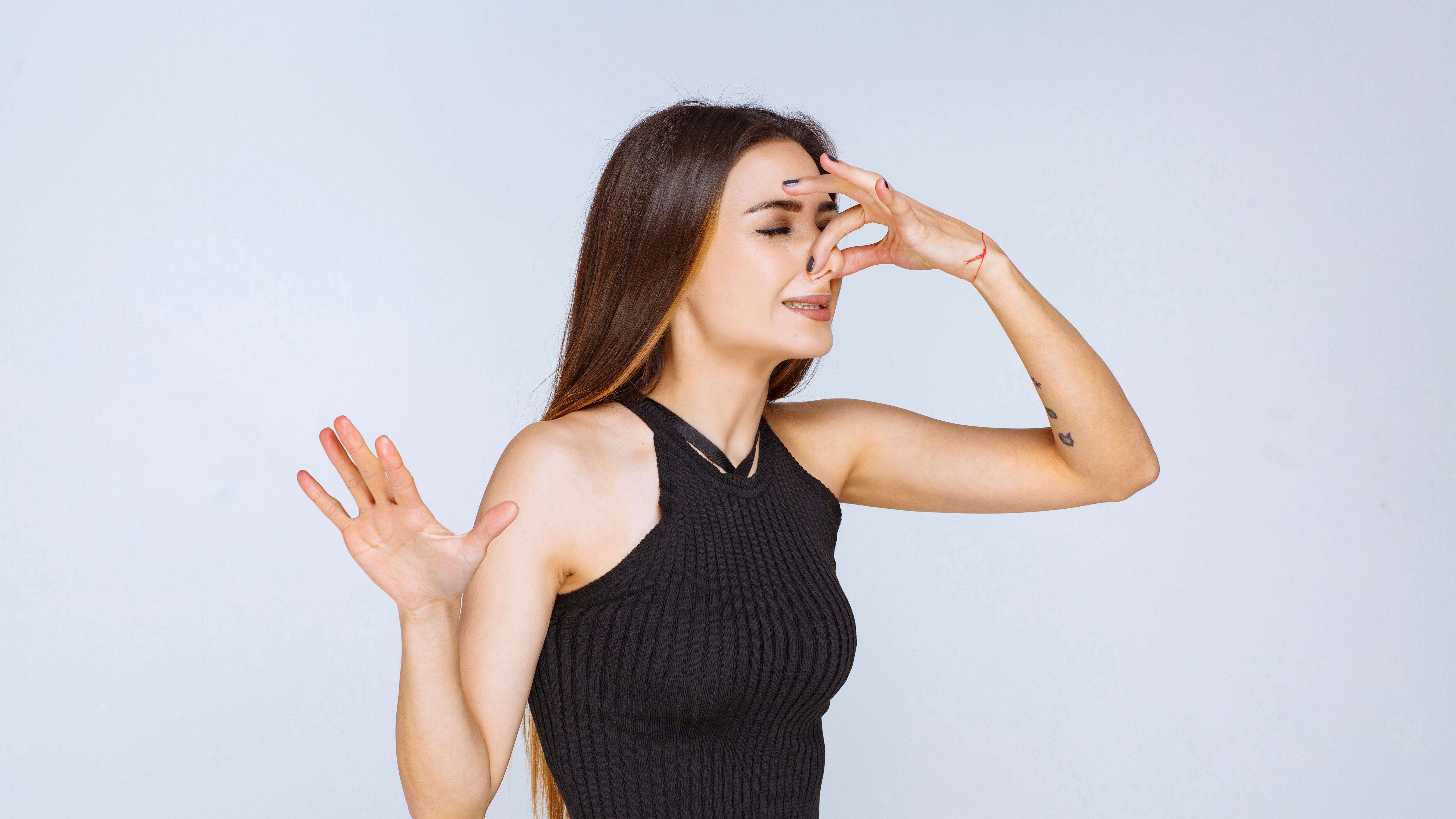 Woman in black shirt feeling bad smell. High quality photo