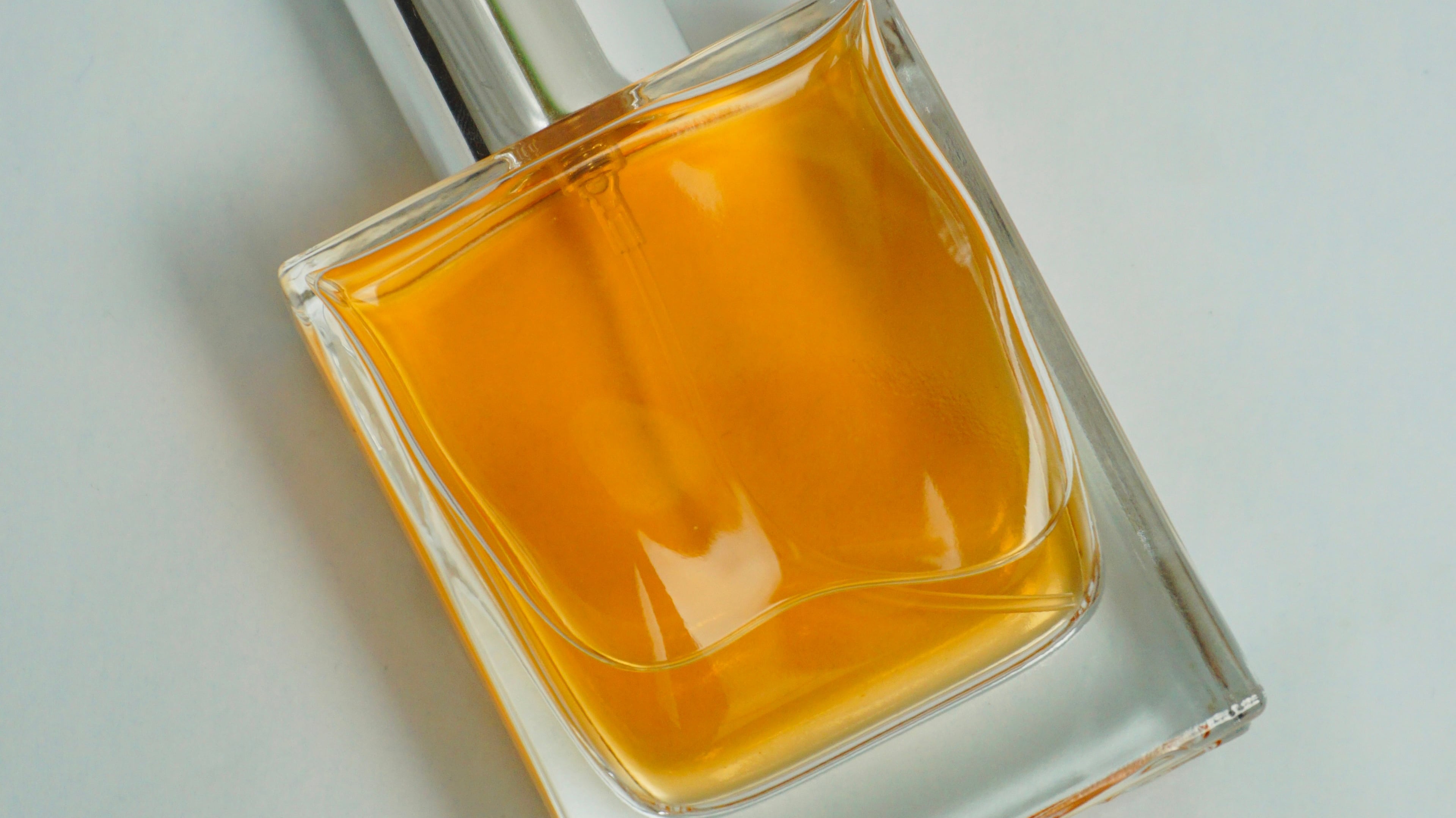 Frasco de perfume com líquido laranja